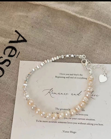 Pearl bracelet on a card with text and 'Aesop' branding in the background