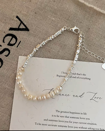 Pearl bracelet on a piece of paper with text