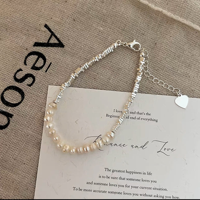 Pearl bracelet on a piece of paper with text