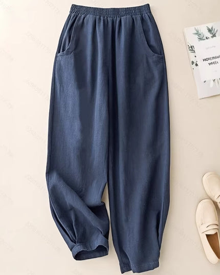 Blue pants on a beige surface with a book and shoes.