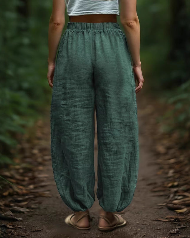 Women wearing green pants standing on a forest path