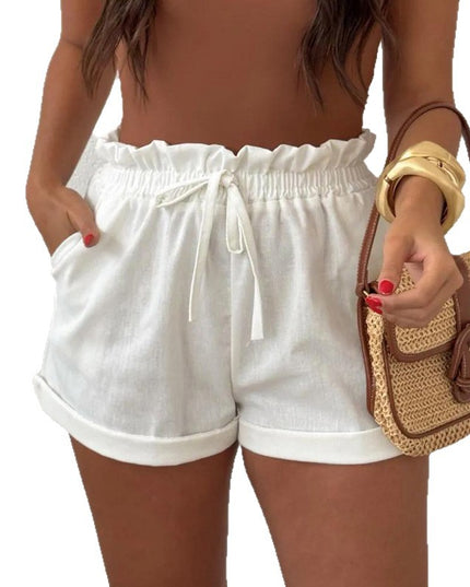 Woman wearing white shorts holding a straw bag on a white background