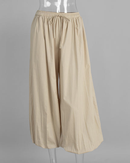 Beige wide-leg pants on a mannequin against a gray background