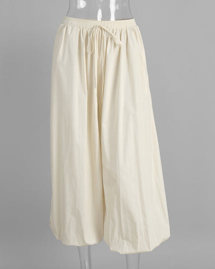 Beige wide-leg pants on a mannequin against a gray background