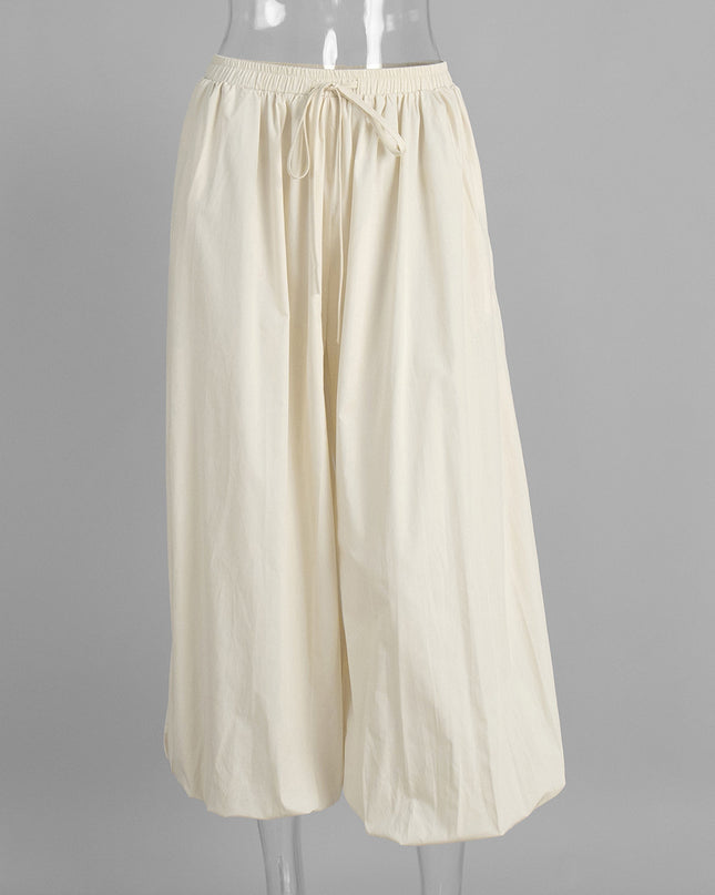 Beige wide-leg pants on a mannequin against a gray background