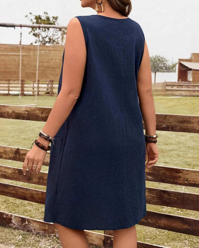 Women wearing a navy blue dress standing near a wooden fence with a grassy field and wooden structures in the background.