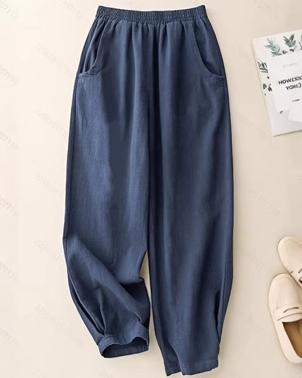 Blue pants on a beige surface with a book and slippers in the background