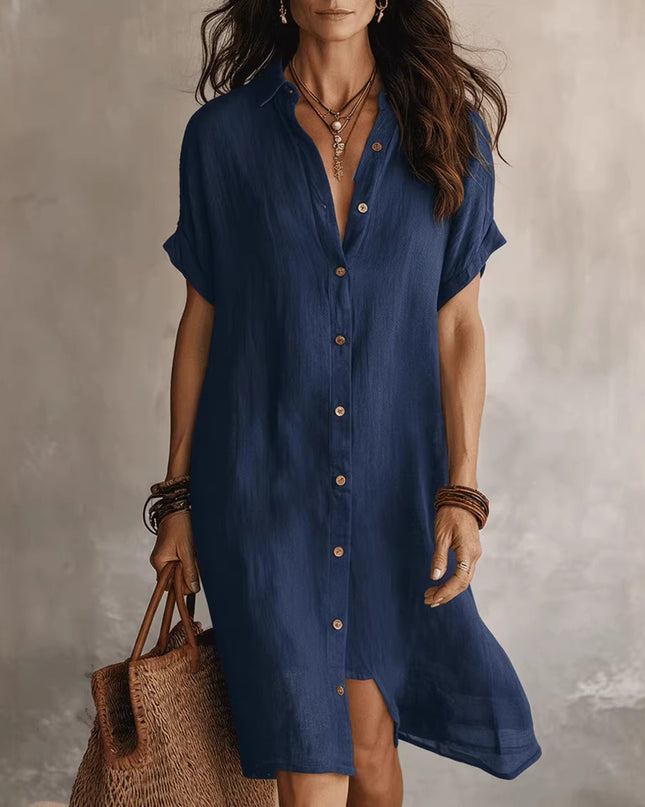 Woman wearing a blue dress holding a brown bag against a gray background