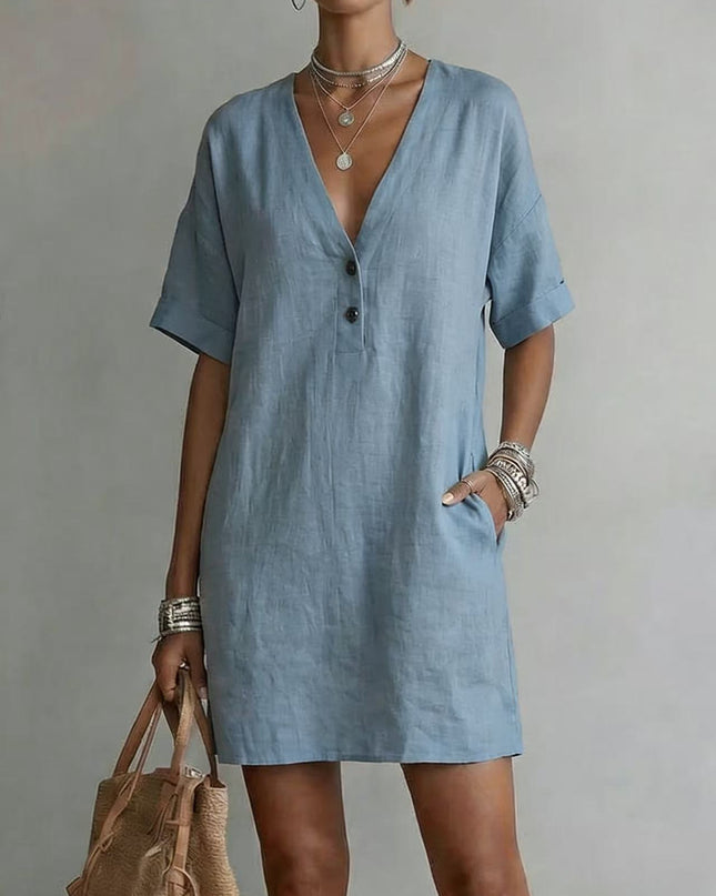 Woman wearing a light blue dress with a plain background