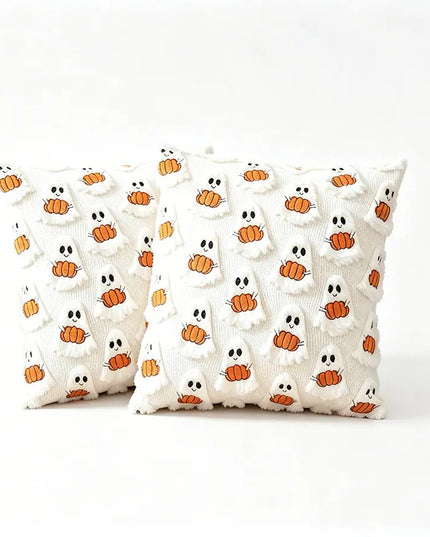 Two square white textured throw pillows with a repeating pattern of orange pumpkins and white ghosts, set against a plain white background.