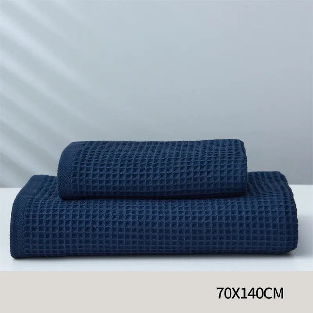 Two blue waffle-textured towels on a white surface with a light gray background.