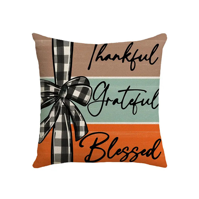Decorative pillow with 'Thankful', 'Grateful', 'Blessed' text and plaid ribbon on a white background