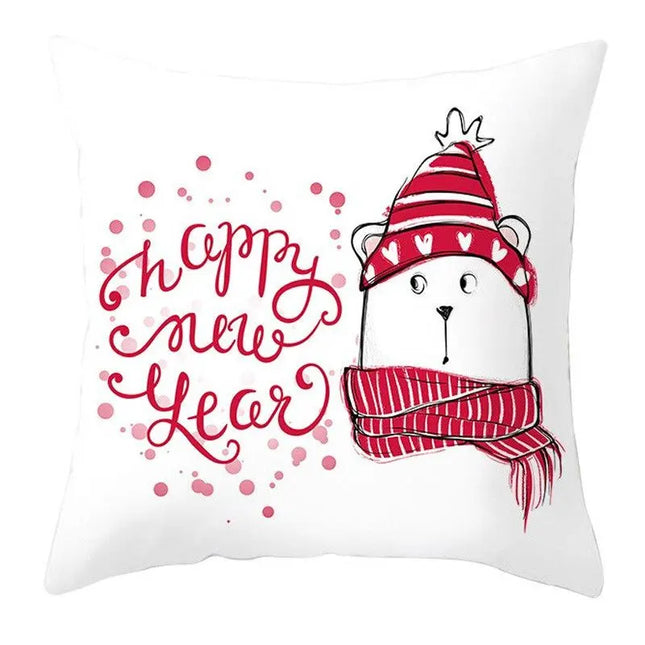 A square white throw pillow featuring a red and pink 'Happy New Year' design with a cartoon polar bear wearing a striped red hat and scarf.