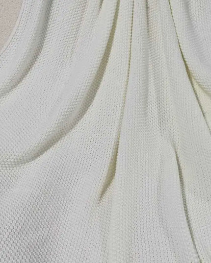 Close up picture of white knitted throw blanket