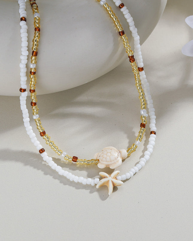 Beaded necklace with starfish charm on a light background