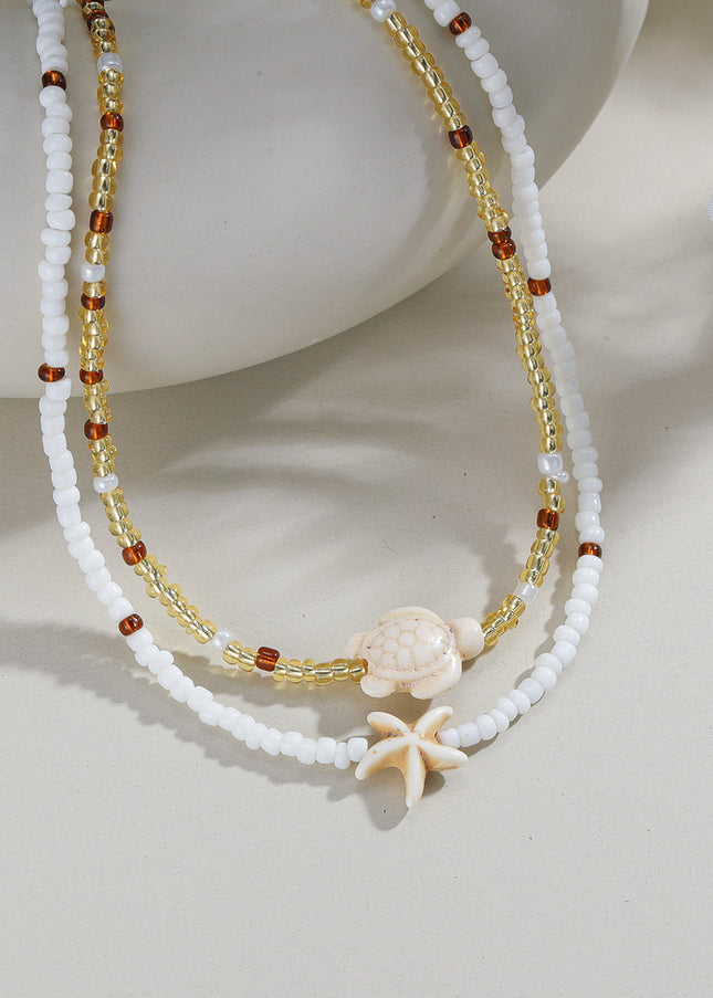 Beaded necklace with starfish charm on a light background