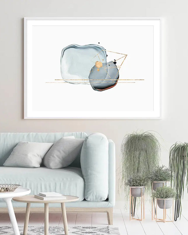 Modern living room with a light blue sofa, decorative plants, and a framed abstract art piece on the wall.