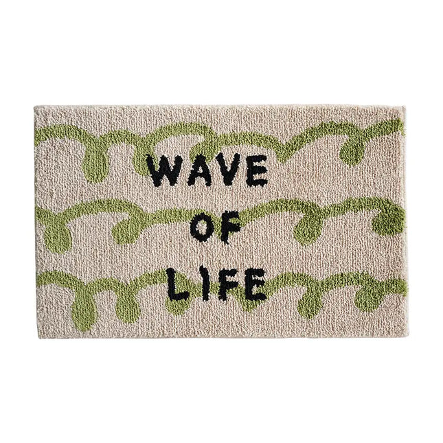 Doormat with 'Wave of Life' text and green leaf patterns on a beige background