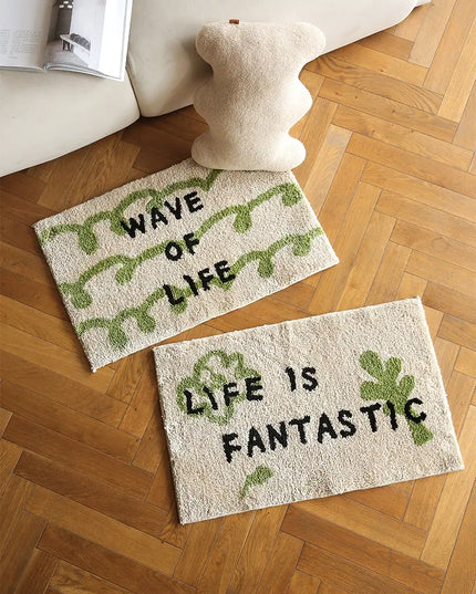 Two decorative mats with text on a wooden floor.