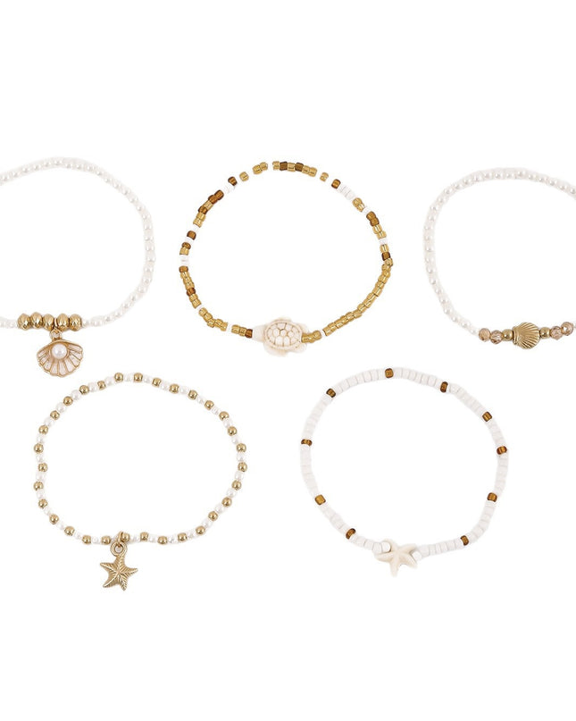 Set of five beaded bracelets with star and shell charms on a white background