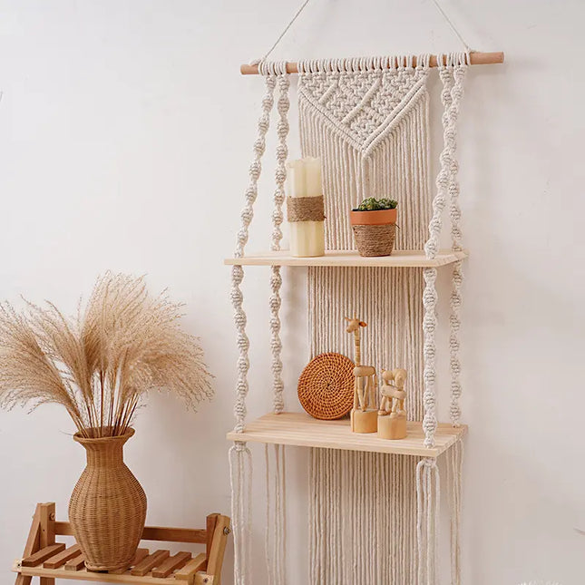 Macrame wall hanging with shelves and decorative items against a white wall