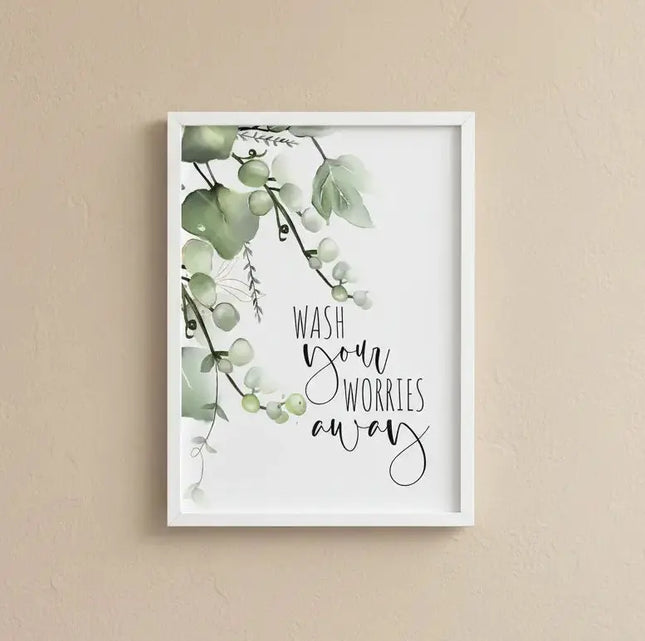 Framed artwork with green leaves and 'Wash your worries away' text on a beige wall.