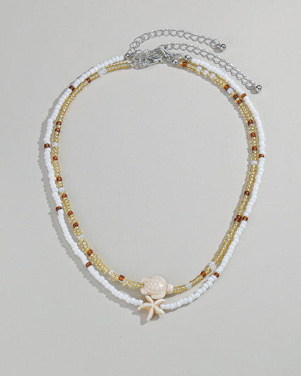 Beaded necklace with starfish charm on a light gray background