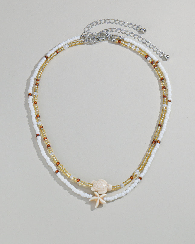 Beaded necklace with starfish charm on a light gray background