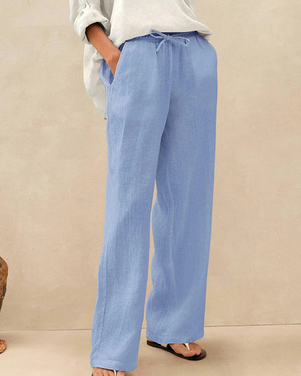 Person wearing light blue pants and a white shirt on a beige background