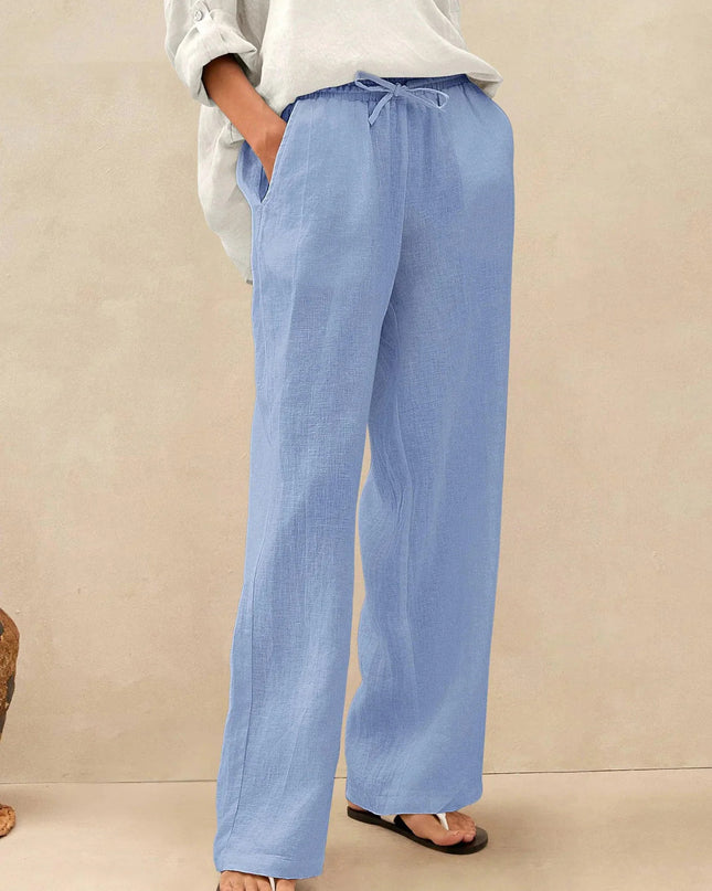 Person wearing light blue pants and a white shirt on a beige background