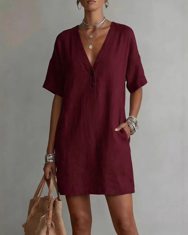 Woman wearing a burgundy dress with a plain background