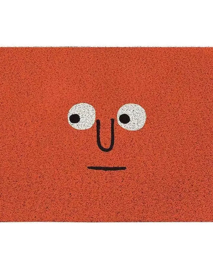 Orange doormat with a face design on a white background