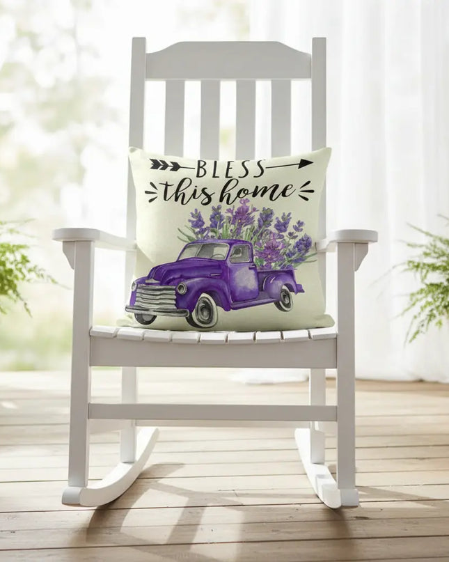 White rocking chair with a decorative pillow featuring a purple truck and 'Bless this home' text on a wooden deck.