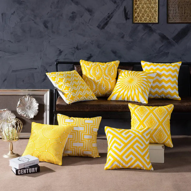Yellow patterned cushions on a sofa against a dark wall with decorative elements.
