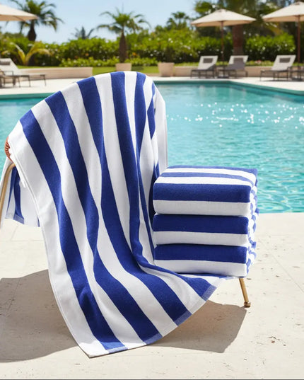 Blue and white striped towel draped over a chair by a poolside.