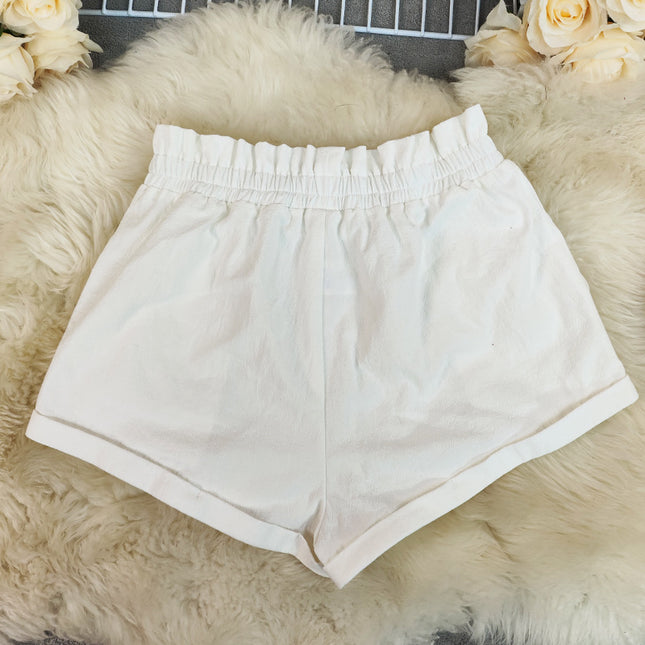 White shorts on a fluffy white surface with flowers around