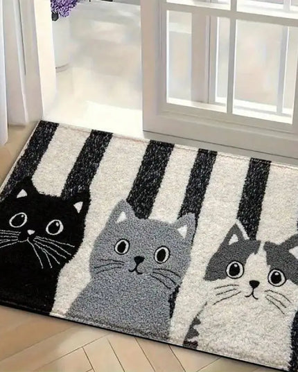 Decorative rug with cat designs on a wooden floor.