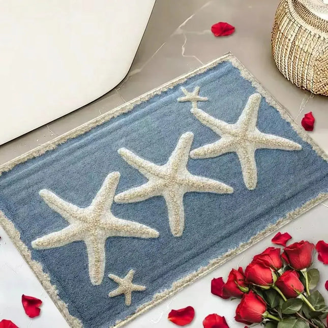 Decorative doormat with starfish design on a floor with red roses and petals.