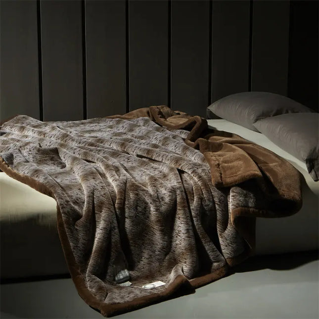 Brown faux fur blanket draped over the bed against a wooden wall.