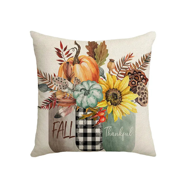 Decorative pillow with autumn-themed design featuring pumpkins, leaves, and a mason jar.