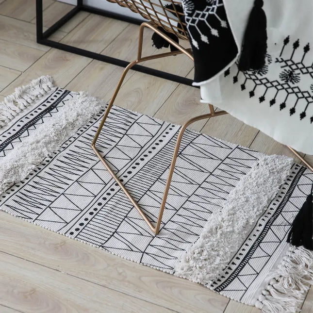 Black and white patterned rug on a wooden floor with a gold chair.