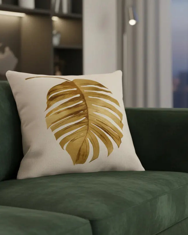 Green sofa with a decorative pillow featuring a leaf design in a modern living room.