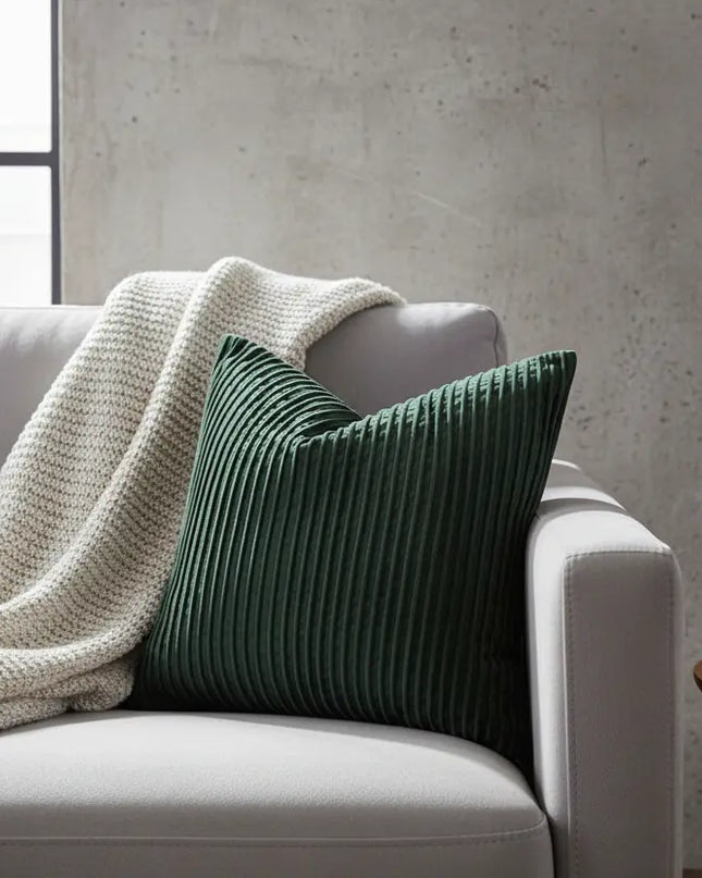 Gray sofa with a dark green pillow and white blanket in a modern living room.