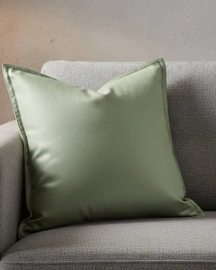 Mint green pillow on a gray sofa against a neutral wall