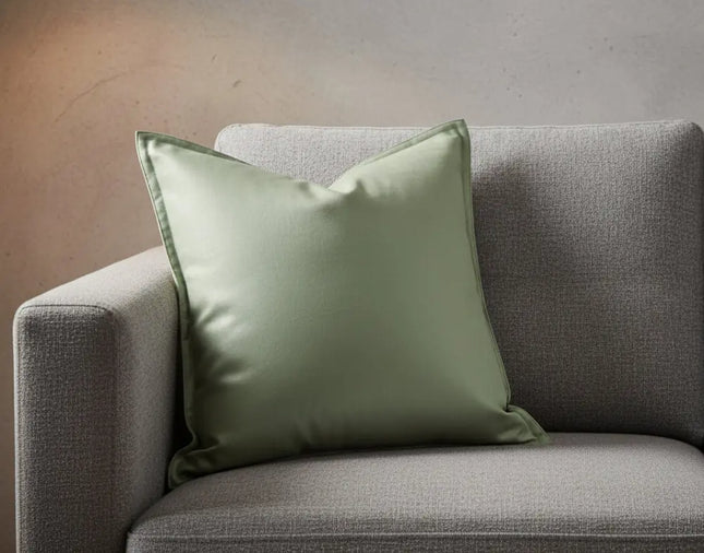 Mint green pillow on a gray sofa against a neutral wall