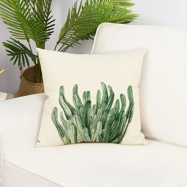 Decorative pillow with cactus design on a white couch with a plant in the background