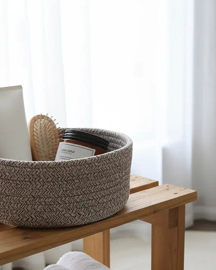 Woven brown and white basket on a wooden bench with a blurred background