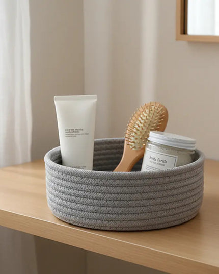 Gray woven basket with toiletries on a wooden surface in a bathroom setting