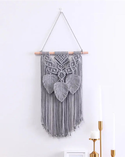 Decorative macrame wall hanging with geometric pattern on a white wall