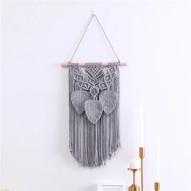 Decorative macrame wall hanging with geometric pattern on a white wall